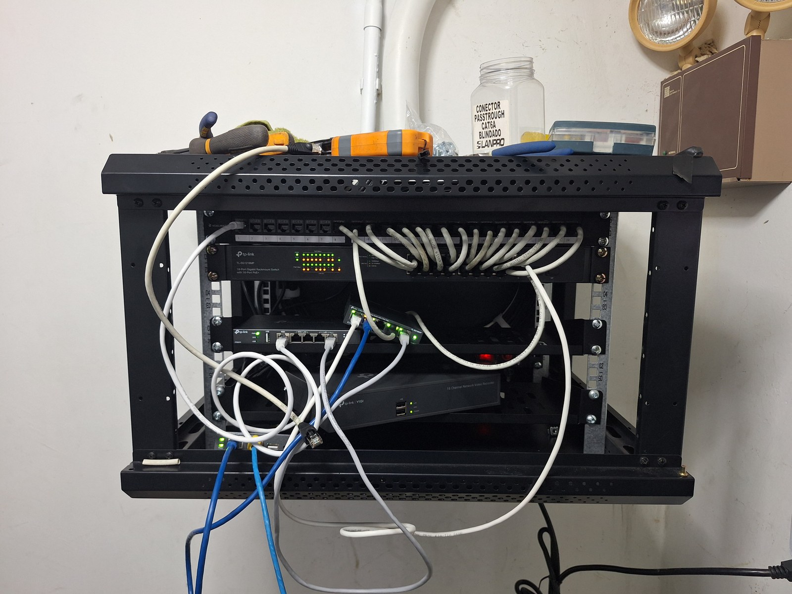 Antes: rack mural con cableado enredado y cables colgando