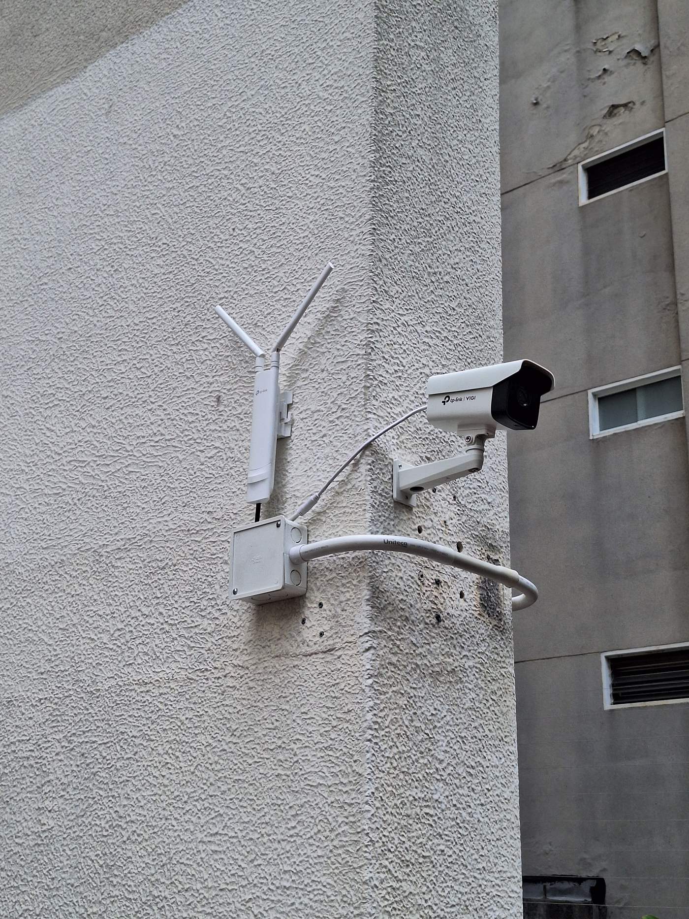 Cámara bullet y antena CPE instaladas en fachada de edificio