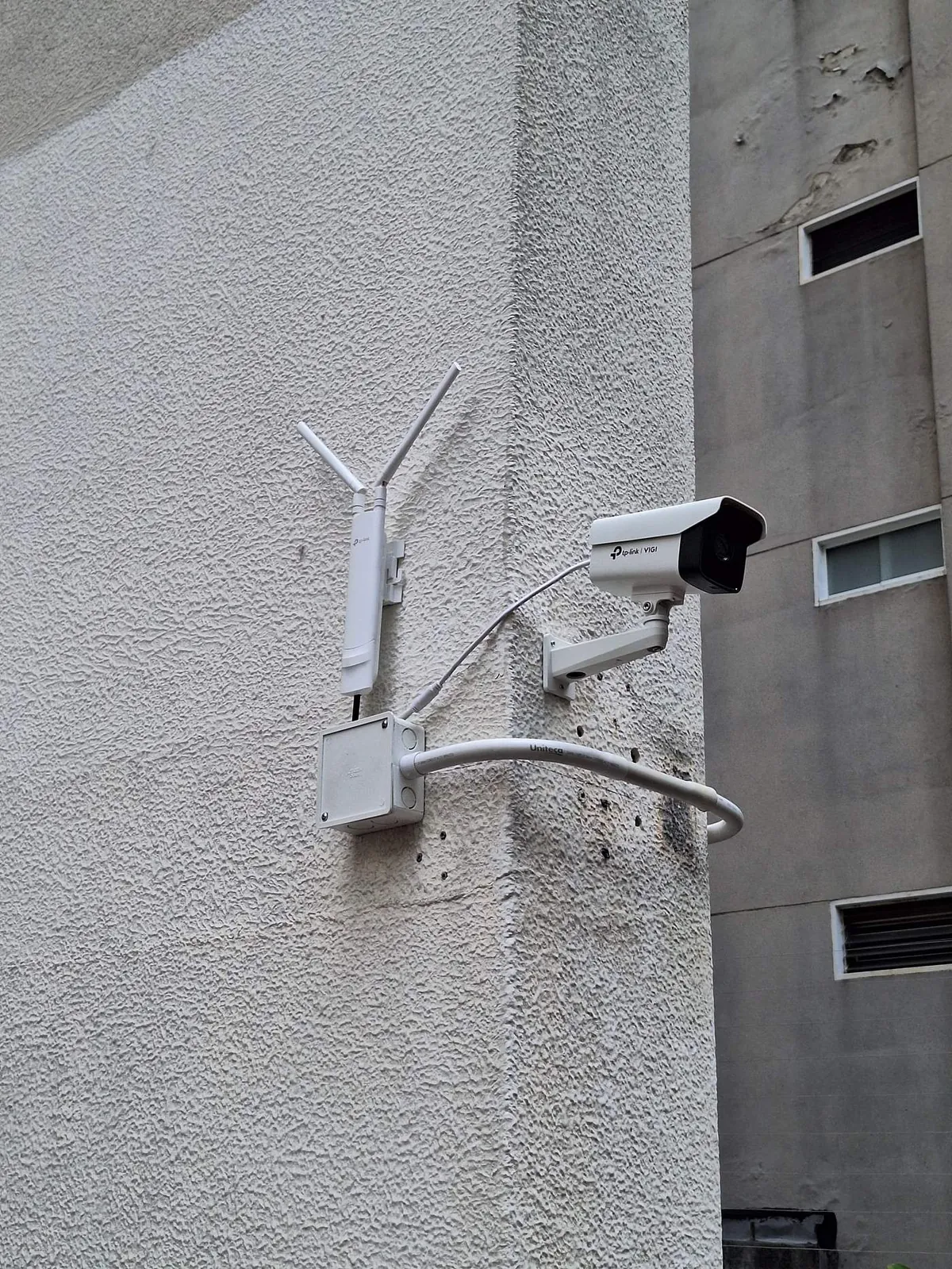 Cámara bullet y antena CPE instaladas en fachada de edificio
