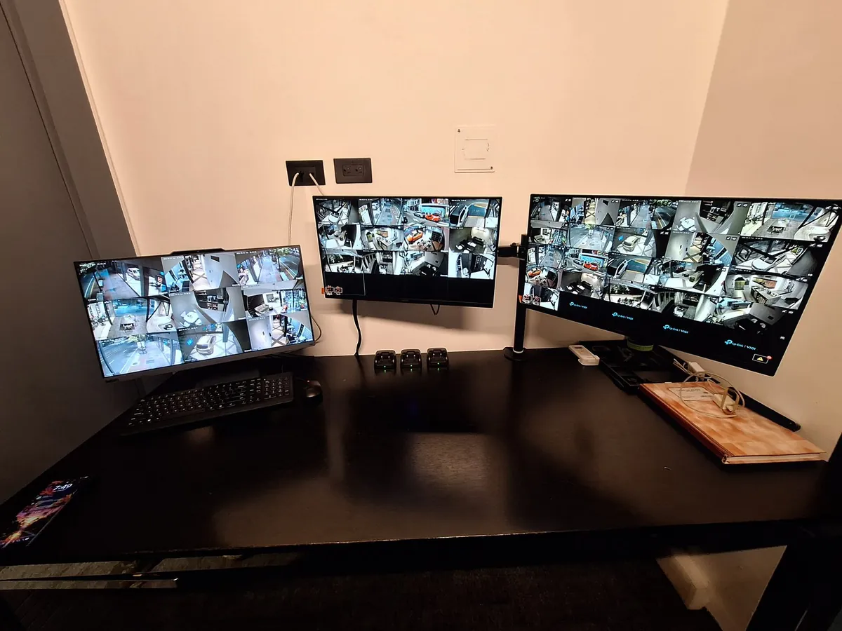 Centro de monitoreo con tres monitores mostrando las cámaras en vivo