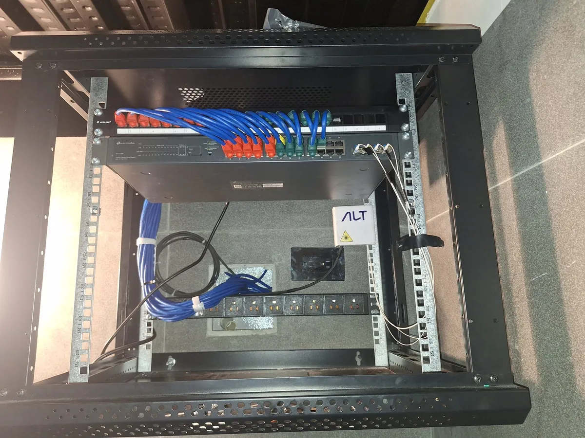 Rack mural con switch TP-Link Omada, patch panel y cableado peinado